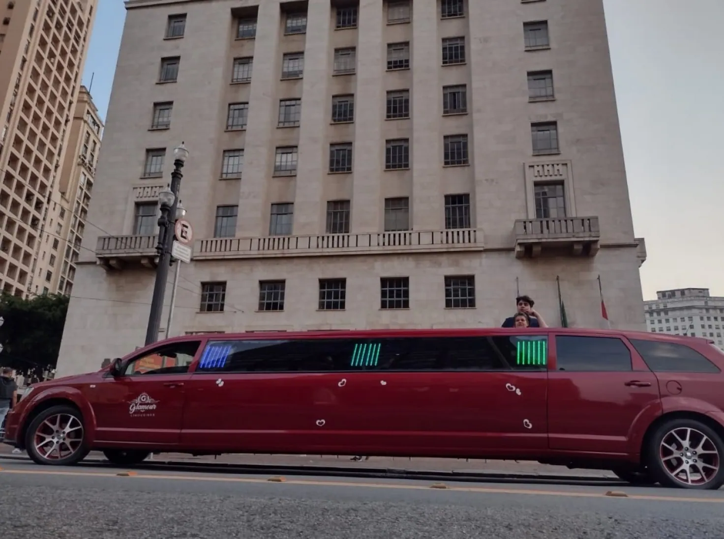 Limousine vermelha Dodge Journey em frente a prédio histórico à noite